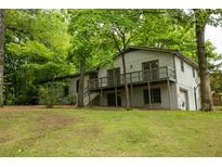 Two-story house with white painted brick, wooden deck, and lush trees surrounding the home at 5384 Blackhawk Dr, Acworth, GA 30102