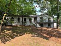 Charming white brick home featuring a spacious front yard and a deck perfect for outdoor relaxation at 5384 Blackhawk Dr, Acworth, GA 30102