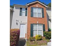 A two-story townhome featuring a brick facade, white siding, and dark green shutters at 315 Saratoga Pl, Riverdale, GA 30296