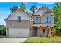 Charming two-story home with brick facade, covered porch, manicured lawn, and two-car garage at 380 Waterbluff Dr, Mableton, GA 30126