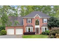 Charming two-story red brick home with an attached two-car garage and beautifully landscaped front yard at 3951 Lorien Nw Way, Kennesaw, GA 30152