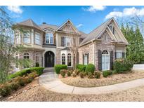 Beautiful two-story home with stone and siding exterior, manicured landscaping, and inviting curb appeal at 8069 Kenstone Ct, Sandy Springs, GA 30350