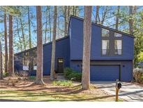 Charming contemporary home with beautiful blue siding and an attached two-car garage at 210 Trailmore Ct, Roswell, GA 30076