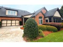 Charming brick home featuring manicured landscaping, a two-car garage, and an inviting sunroom at 120 Chastain Nw Rd # 1104, Kennesaw, GA 30144