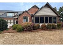 Charming home featuring a brick facade, manicured landscaping, and a cozy screened porch area at 120 Chastain Nw Rd # 1104, Kennesaw, GA 30144