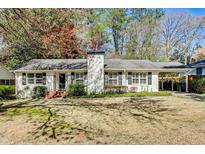 Charming single-story home with a white brick chimney, black shutters, and a convenient carport at 2984 Westminster Cir, Atlanta, GA 30327