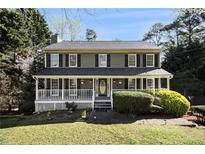 Charming two-story home featuring a welcoming front porch and well-maintained landscaping at 1472 Hartman Sw Dr, Lilburn, GA 30047