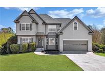 Charming two-story home with gray siding, manicured lawn, and an attached two-car garage at 3670 Cedar Springs Ln, Loganville, GA 30052