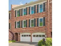 Charming brick townhome with two-car garage, green shutters, and manicured landscaping at 249 The South Chace Ne, Atlanta, GA 30328