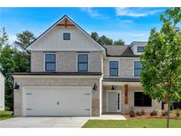Charming two-story home with a two-car garage, a gray brick facade, and manicured front yard at 376 Waterbluff Dr, Mableton, GA 30126