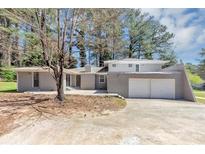 Charming single-story home features a two-car garage and gray brick exterior at 1507 Fair Haven Dr, Riverdale, GA 30296