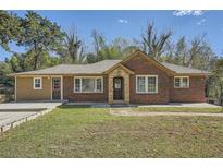 Charming brick home featuring a covered porch, well-manicured lawn, and a convenient driveway at 2836 Waters Sw Rd, Atlanta, GA 30354