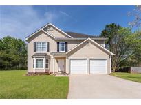 Charming two-story home featuring a well-maintained lawn, attached two-car garage, and classic siding at 2485 Field Spring Dr, Stonecrest, GA 30058