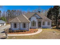 Charming single-story home boasting unique architectural details, neutral color palette, and well-manicured landscaping at 7025 Bavarian Wood Pl, Buford, GA 30518