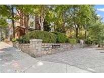 Charming brick building entrance with stone wall and manicured landscaping at 850 Piedmont Ne Ave # 3304, Atlanta, GA 30308