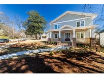 Charming two-story home featuring a welcoming front porch with brick accents and a well-manicured lawn at 585 Sherwood Ne Rd, Atlanta, GA 30324