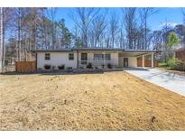 Charming one-story home featuring a covered carport and a freshly painted exterior at 5109 Dogwood Hills Dr, Sugar Hill, GA 30518