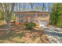 Charming brick home featuring a well-manicured lawn and an attached garage at 4564 Cypress Ridge Ct, Stone Mountain, GA 30083