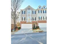 Charming townhome showcasing a brick and siding exterior with an attached garage and a well-manicured lawn at 376 Eagle Tiff Dr, Sugar Hill, GA 30518