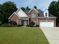 Charming brick home with a well-manicured lawn and attached two-car garage, perfect for suburban living at 275 Rose Ivy Ct, Lawrenceville, GA 30043