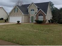 Charming two-story home with a well-maintained lawn and attached two-car garage at 145 Berkshire Dr, Covington, GA 30016