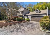 Charming townhome featuring a well-manicured lawn, beautiful trees, and an attached two-car garage at 2914 Lenox Ne Rd # 12, Atlanta, GA 30324