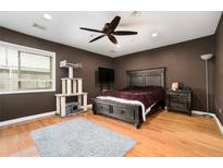 A cozy bedroom featuring hardwood floors, a ceiling fan, and neutral brown walls at 3501 Roswell Ne Rd, Atlanta, GA 30305