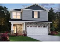 Charming two-story home featuring stone accents, a two-car garage, and a well-manicured lawn at 4825 Marjorie Dr, Cumming, GA 30041