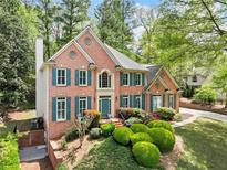 Charming brick home featuring a well-manicured lawn and teal shutters at 535 Woodbrook Way, Lawrenceville, GA 30043