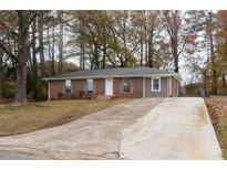 Charming brick home with a well-maintained lawn and long driveway at 679 Winchester Ln, Norcross, GA 30071