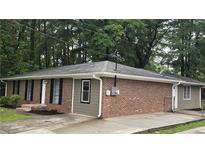 Cozy home featuring a blend of classic brick and modern vinyl siding, complemented by a well-maintained landscape at 679 Winchester Ln, Norcross, GA 30071
