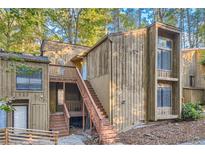 A charming condo featuring a wooden exterior and staircase in a wooded setting at 3111 Fairington Dr, Lithonia, GA 30038