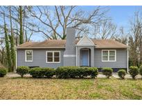 Charming single-story home with blue front door, manicured landscaping, and grey painted brick chimney at 360 Peyton Sw Rd, Atlanta, GA 30311