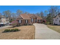 Charming brick home featuring a well-manicured lawn and long driveway at 160 Glenmore Ln, Mcdonough, GA 30253