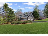Charming two-story home featuring a well-manicured lawn, two-car garage and a welcoming front porch at 5635 Charleston Bay Dr, Cumming, GA 30041