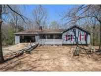 Charming ranch home features an open carport, a front porch and a spacious yard at 180 Sable Cir, Covington, GA 30016