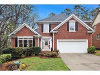 Charming brick home featuring a manicured lawn, two-car garage, and traditional architectural details at 4236 Providence Ln, Tucker, GA 30084