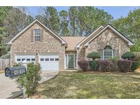 Charming brick home with a well-manicured lawn and a two-car garage at 1312 Birch Ct, Lithonia, GA 30058