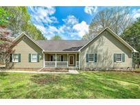 Charming ranch home featuring a front porch and well-manicured lawn surrounded by mature trees at 195 Creekside Way, Mcdonough, GA 30252