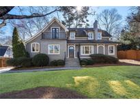 Charming two-story home featuring a cozy front porch and balcony, and a well-manicured lawn at 2993 Saint Annes Nw Ln, Atlanta, GA 30327