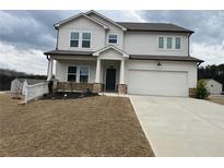 Charming two-story home with a two-car garage, inviting porch, and manicured lawn on an overcast day at 14 Ledgemont Way, Acworth, GA 30101