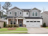 Charming two-story home featuring stone accents, a well-manicured lawn, and a two-car garage at 708 Chipping Sparrow St, Canton, GA 30115