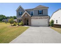 Charming two-story home featuring a brick-and-stone facade, gray siding, and a two-car garage at 1151 Wisteria Sw Dr, Mableton, GA 30126