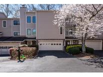 Inviting townhome exterior with attached garage and lovely flowering tree in the front yard at 58 Basswood Cir # 29, Atlanta, GA 30328