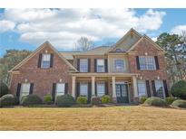 Stately brick home with a symmetrical facade, manicured landscaping, and a covered front porch at 4020 Inman Park Lane, Buford, GA 30519