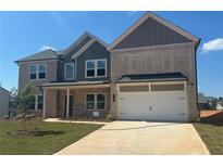 Newly constructed two-story home boasting a brick facade, a two-car garage and a well-manicured lawn at 58 Longhorn Way, Auburn, GA 30102