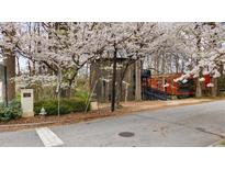 Unique home design with blooming trees in a wooded setting, featuring multi-level decks and a combination of wood and brick finishes at 595 Overbrook Nw Dr, Atlanta, GA 30318