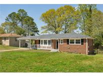 Charming brick home featuring a cozy front porch, carport, and a well-maintained lawn at 2792 Toney Dr, Decatur, GA 30032