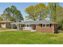 Charming single-story brick home with a well-maintained lawn and inviting front porch at 2792 Toney Dr, Decatur, GA 30032