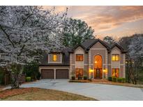 Charming two-story home featuring arched windows, mature trees, two-car garage and beautiful landscaping at 275 Tynebrae Pl, Roswell, GA 30075